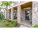 Inviting front porch featuring brick accents, a seating area, and a charming entrance to a well-maintained townhome at 963 South On Main Dr, Woodstock, GA 30188