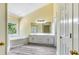 Bathroom with a large window, soaking tub, dual sinks, and enclosed shower at 1002 Saddle Hl, Marietta, GA 30068
