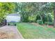 The backyard shows lush grass, mature trees, stone-edged flowerbeds, and stone patio at 1356 Emory Ne Rd, Atlanta, GA 30306