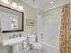 Bathroom featuring tile floors, a pedestal vanity, toilet, tub, and bright lighting at 1356 Emory Ne Rd, Atlanta, GA 30306