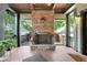 Inviting covered porch featuring a stone fireplace, tile flooring, and comfortable seating area at 1356 Emory Ne Rd, Atlanta, GA 30306