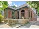 Beautiful brick home with a stone porch and arched entryway, featuring green trim and a well-manicured lawn at 1356 Emory Ne Rd, Atlanta, GA 30306