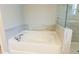 A white bathtub has chrome fixtures and decorative gray and white marbled tile at 360 Hayden Cir, Woodstock, GA 30189