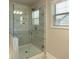 Bathroom shower with glass doors, decorative tiles and a window at 360 Hayden Cir, Woodstock, GA 30189