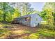 Exterior view of home's backyard featuring a wood deck and lawn surrounded by mature trees at 4650 Big Valley Ct, Stone Mountain, GA 30083