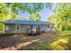 Backyard featuring a small deck that leads to a spacious yard surrounded by trees at 4650 Big Valley Ct, Stone Mountain, GA 30083