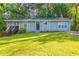 Charming single-story home featuring a well-manicured lawn, inviting entryway, and a serene, tree-lined backdrop at 4650 Big Valley Ct, Stone Mountain, GA 30083