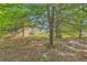 Home featuring mature trees, green grass, and partial view of the home's exterior at 484 Cathedral Dr, Mcdonough, GA 30253