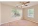 Bright bedroom featuring neutral walls, carpet, a ceiling fan, and two large windows at 484 Cathedral Dr, Mcdonough, GA 30253