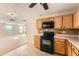 Well-lit kitchen with black appliances and light wood cabinets offers a functional and stylish space at 484 Cathedral Dr, Mcdonough, GA 30253