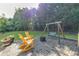 Landscaped backyard with patio, rocking chairs, and a swing set at 850 Old Spring Way, Sugar Hill, GA 30518