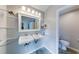 Bathroom with double sinks, floating shelves, and tiled floor at 850 Old Spring Way, Sugar Hill, GA 30518