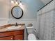 Well-lit bathroom featuring a round mirror, decorative shower curtain, and a pedestal sink at 850 Old Spring Way, Sugar Hill, GA 30518