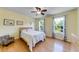 Bright bedroom featuring hardwood floors, a ceiling fan, and two windows with picturesque views at 850 Old Spring Way, Sugar Hill, GA 30518