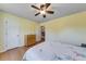 Comfortable bedroom featuring hardwood floors, a ceiling fan, and a view into another room at 850 Old Spring Way, Sugar Hill, GA 30518