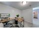 Functional home office with a large screen monitor, wooden desk, and adjacent hallway at 850 Old Spring Way, Sugar Hill, GA 30518