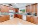 Bright kitchen featuring wooden cabinets, white appliances, and a mosaic backsplash at 850 Old Spring Way, Sugar Hill, GA 30518