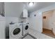 Efficient laundry room featuring modern white front-load washer and dryer units and white cabinets at 850 Old Spring Way, Sugar Hill, GA 30518
