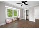 Bedroom with hardwood floors, a modern ceiling fan, and large windows offering scenic outdoor views at 550 Stewart Nw Ave, Marietta, GA 30064