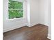 Bright and minimalist bedroom with hardwood floors and a large window offering views of the neighborhood at 550 Stewart Nw Ave, Marietta, GA 30064