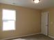 Well-lit bedroom with neutral walls, a window, and a white door with white trim accents at 2197 Boxwood Cir, Conyers, GA 30094