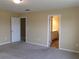 Carpeted bedroom with neutral walls, and a view into the attached bathroom and closet areas at 2197 Boxwood Cir, Conyers, GA 30094