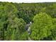 Aerial shot of a home surrounded by a dense green canopy of trees, revealing the roof and facade at 3953 Lorien Nw Way, Kennesaw, GA 30152