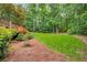 Expansive backyard featuring a wooden deck, lush lawn, and serene wooded backdrop at 3953 Lorien Nw Way, Kennesaw, GA 30152