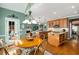 Open kitchen with a dining area, hardwood floors, central island, wood cabinetry, and stainless steel appliances at 3953 Lorien Nw Way, Kennesaw, GA 30152