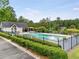Community pool with clear water, surrounded by a fence, green shrubs and a cabana at 3953 Lorien Nw Way, Kennesaw, GA 30152