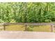 Backyard deck with wooden railings overlooks a lush, green, landscaped yard with surrounding trees at 4016 Nations Dr, Douglasville, GA 30135
