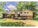 Two-story home with a brick exterior, rear deck, lush lawn, and mature trees in the backyard at 4016 Nations Dr, Douglasville, GA 30135