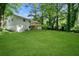 Expansive backyard with lush green lawn, mature trees, and a deck provides privacy and space for outdoor enjoyment at 1386 Pineglen Dr, Riverdale, GA 30296