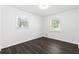 Bedroom featuring hardwood floors, two windows, and neutral walls at 1386 Pineglen Dr, Riverdale, GA 30296