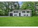 Traditional-style home with an expansive green lawn and attached garage at 1386 Pineglen Dr, Riverdale, GA 30296