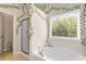 Bathroom showcasing a bathtub with a shower, a large window, and decorative vines at 1749 Charcoal Ives Rd, Lawrenceville, GA 30045