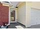 Inviting front entrance with glass door, brick detail, and neutral siding leading to an attached two-car garage at 1835 Patrick Mill, Buford, GA 30518