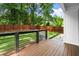 Wide deck with wooden floors, black railings, and view of grassy backyard and fence at 32 Wadley Nw St, Atlanta, GA 30314