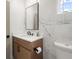 Stylish bathroom featuring marble walls, a floating wood vanity, and contemporary black fixtures at 32 Wadley Nw St, Atlanta, GA 30314