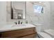 Stylish bathroom featuring marble walls, a floating wood vanity, and contemporary black fixtures at 32 Wadley Nw St, Atlanta, GA 30314