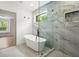 Modern bathroom featuring a freestanding tub, glass shower, and marble tiling at 32 Wadley Nw St, Atlanta, GA 30314