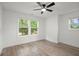 Bright, open bedroom with three windows and modern ceiling fan and light colored wood flooring at 32 Wadley Nw St, Atlanta, GA 30314