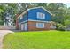 Charming two-story home featuring a well-manicured front lawn and brick and blue siding at 4593 Bexley Way, Stone Mountain, GA 30083