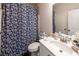 Traditional-style bathroom with blue floral shower curtain, white sink, and vanity at 98 Heritage Pointe Dr, Villa Rica, GA 30180