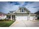 Charming home with green siding, white garage doors, and a well-manicured lawn on a sunny day at 98 Heritage Pointe Dr, Villa Rica, GA 30180