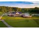 Exterior view of golf course clubhouse featuring multi-level patio, stone foundation, and lush green lawns at 98 Heritage Pointe Dr, Villa Rica, GA 30180