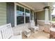 Close-up of the charming front porch with rocking chairs, a small table, and an inviting welcome at 98 Heritage Pointe Dr, Villa Rica, GA 30180
