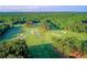 Aerial view of scenic golf course featuring manicured lawns, sand traps, trees, and pond at 98 Heritage Pointe Dr, Villa Rica, GA 30180