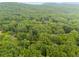 Aerial view of property line in heavily wooded area with the home near the center at 2055 Timberland Dr, Cumming, GA 30040