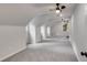 Spacious attic room with neutral carpet, white walls, and ceiling fans at 2055 Timberland Dr, Cumming, GA 30040